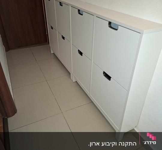 ארון לבן עם דלתות במעבר צר